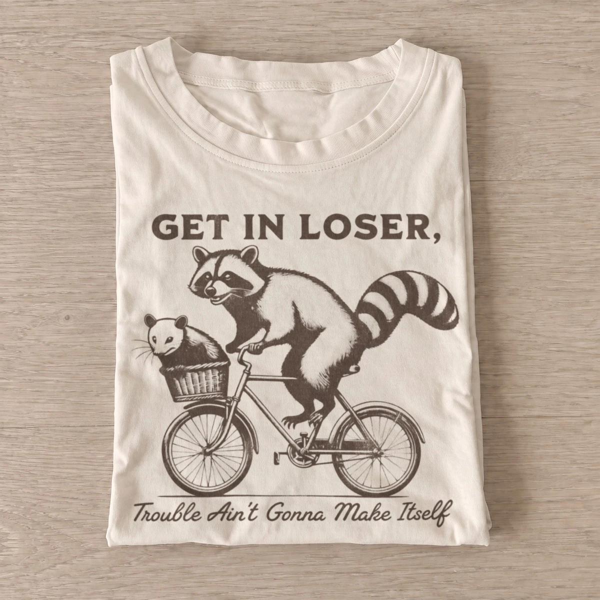 Get in loser trouble bicycle raccoon t shirt sand20trouble bicycle raccoons.webp