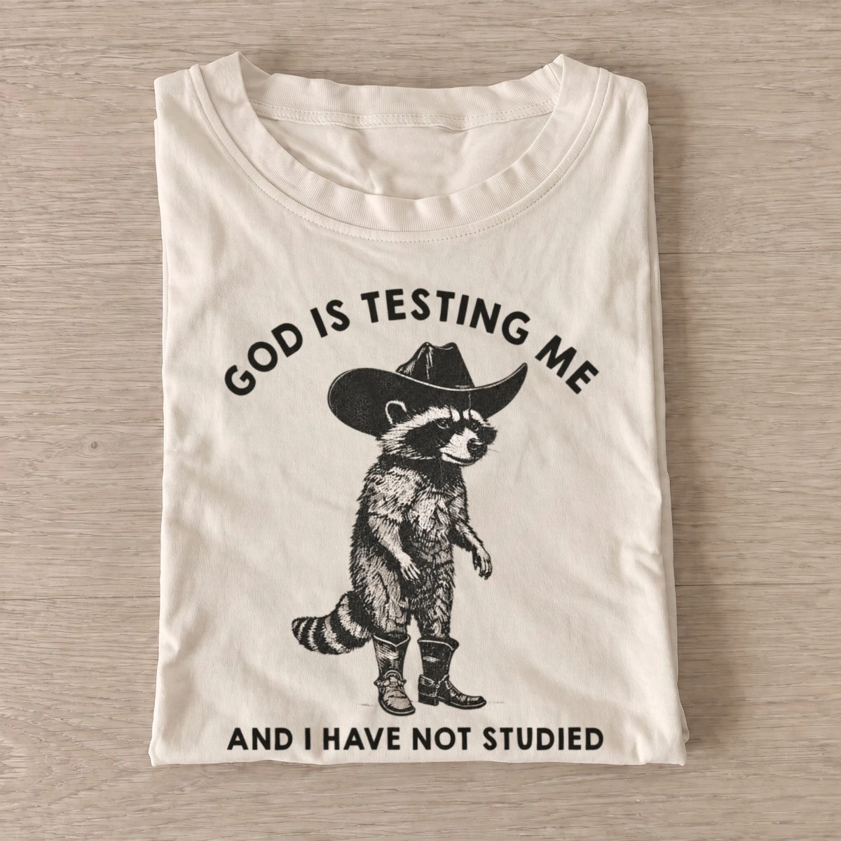 God is testing me cowboy raccoon t shirt sand20god tests raccoon.webp