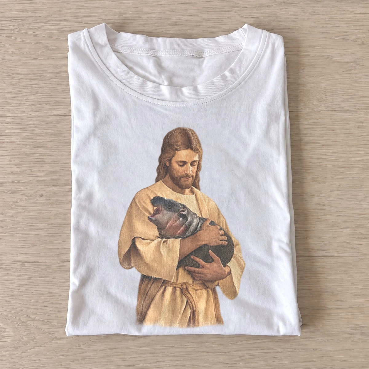 Jesus holding baby hippo t shirt white20jesus and hippo.webp
