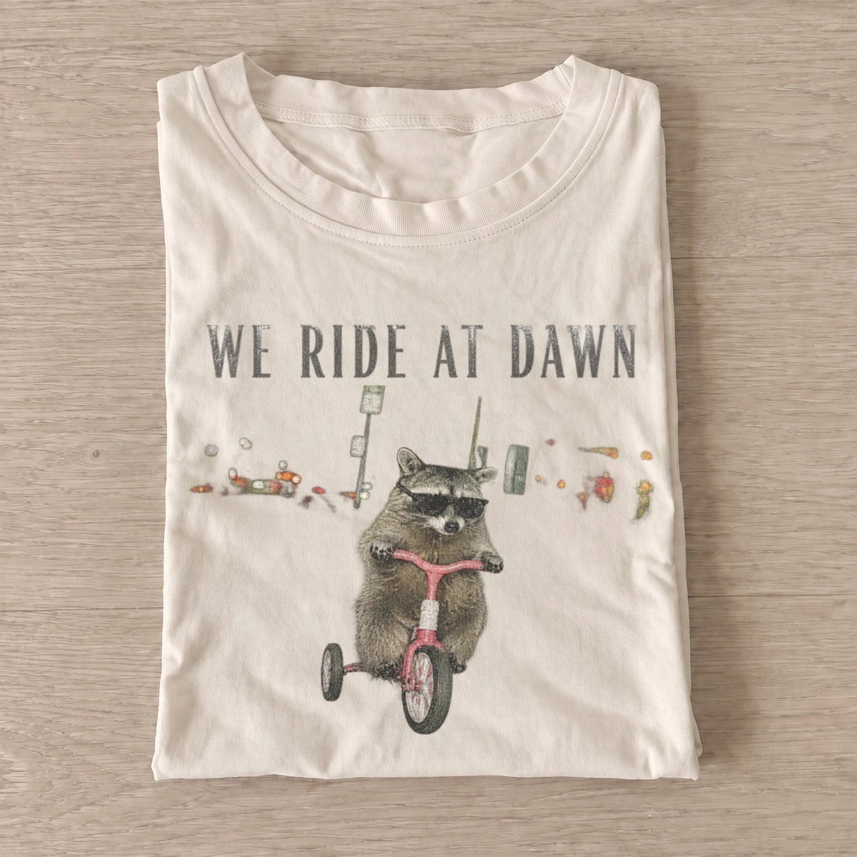 We ride at dawn raccoon t shirt sand20ride at dawn raccoon.webp
